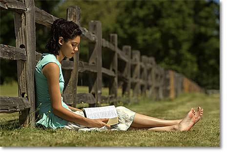 Girl reading her Bible outdoors
